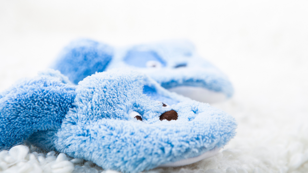 boys blue rabbit slippers on a white rug