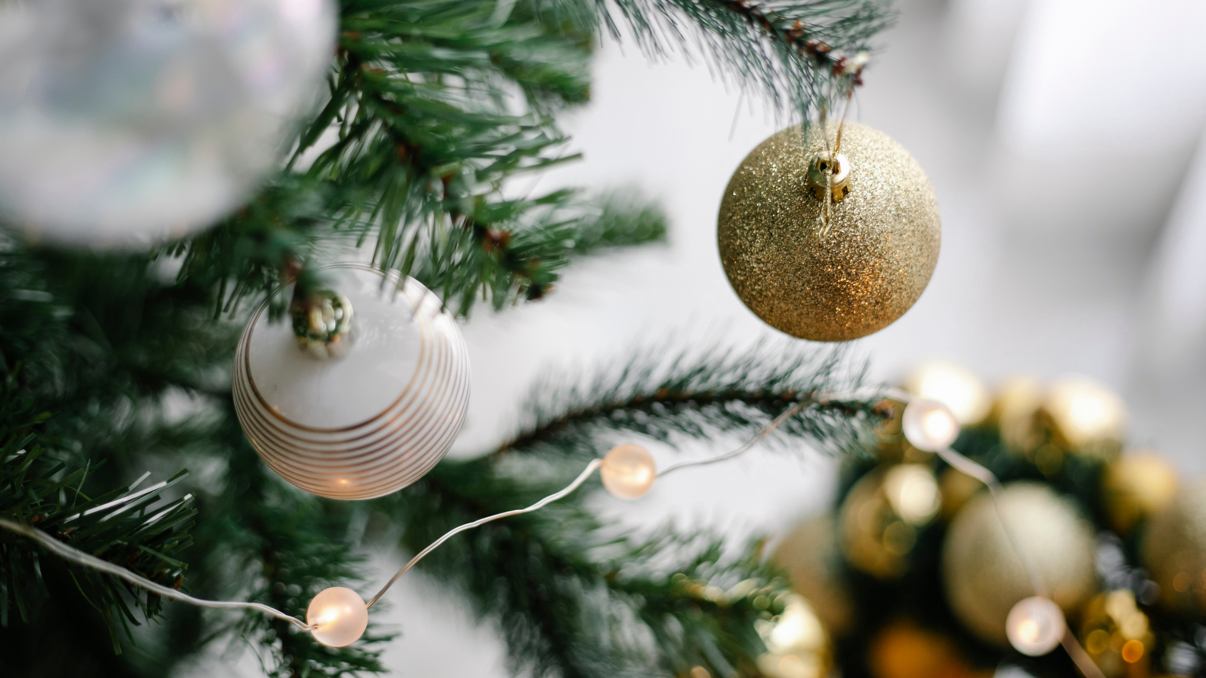 close up of christmas tree with gold and white glitter baubles