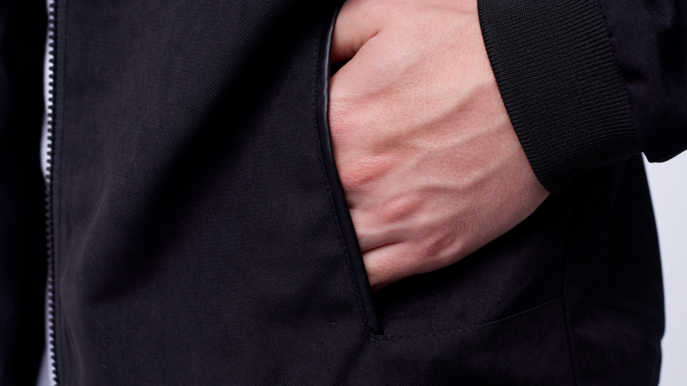 close up of mans hand in bomber jacket pocket