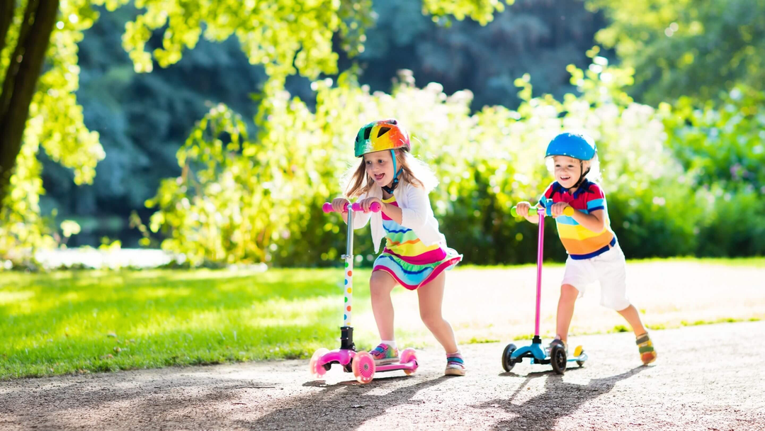 little boy and girl playing on their scooters outdoor at the park