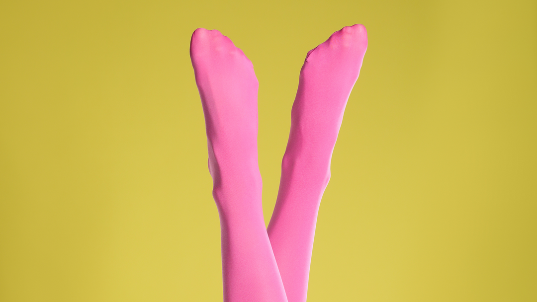 person wearing bold pink tights against a yellow background