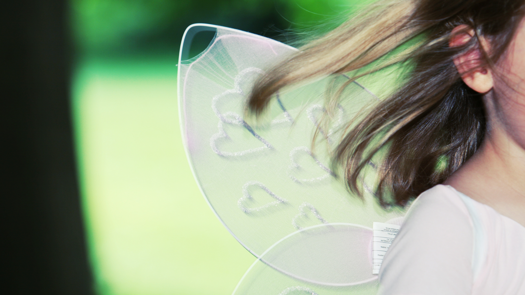 little girl wearing white fairy wings with love heart design