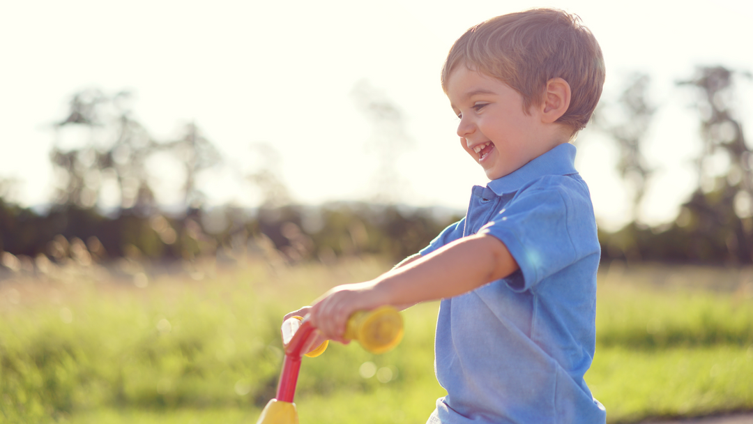 little boy on bike wearing blue colour top