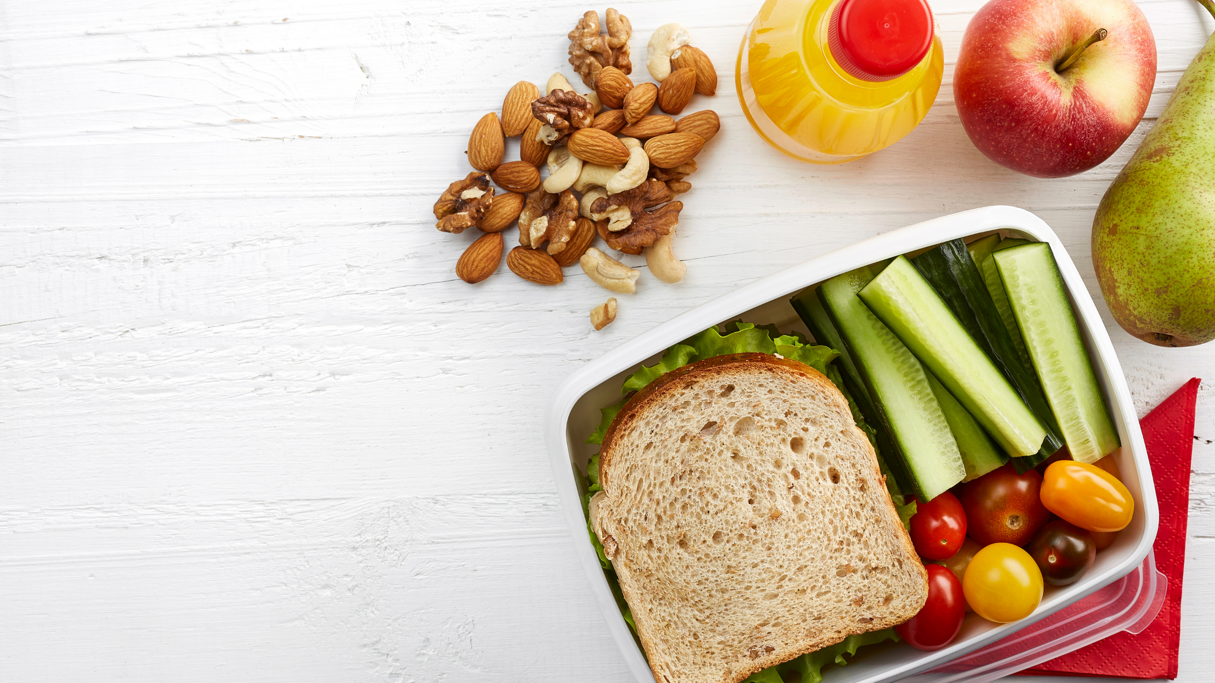 top view of lunch box filled with sandwiches, celery sticks and tomatoes