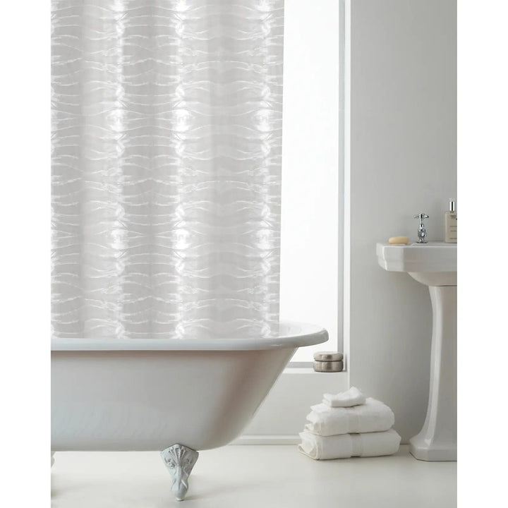 Transparent 3D waves pattern shower curtain hanging over a bath with white towels and sink