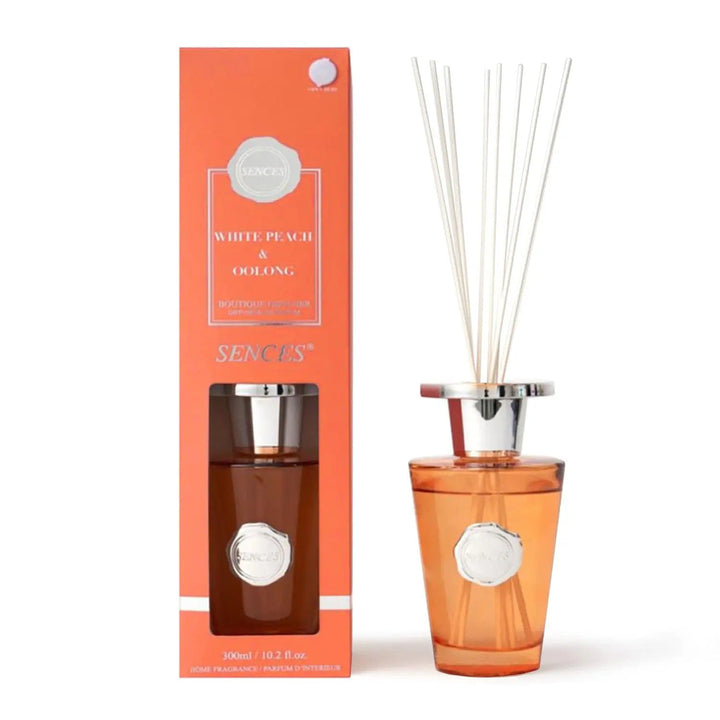 White Peach & Oolong scented diffuser in orange with silver top bottle and white reeds