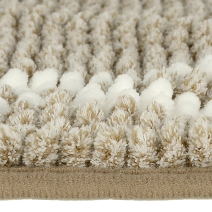 Side profile of beige and white bobbles on a noodle bath mat