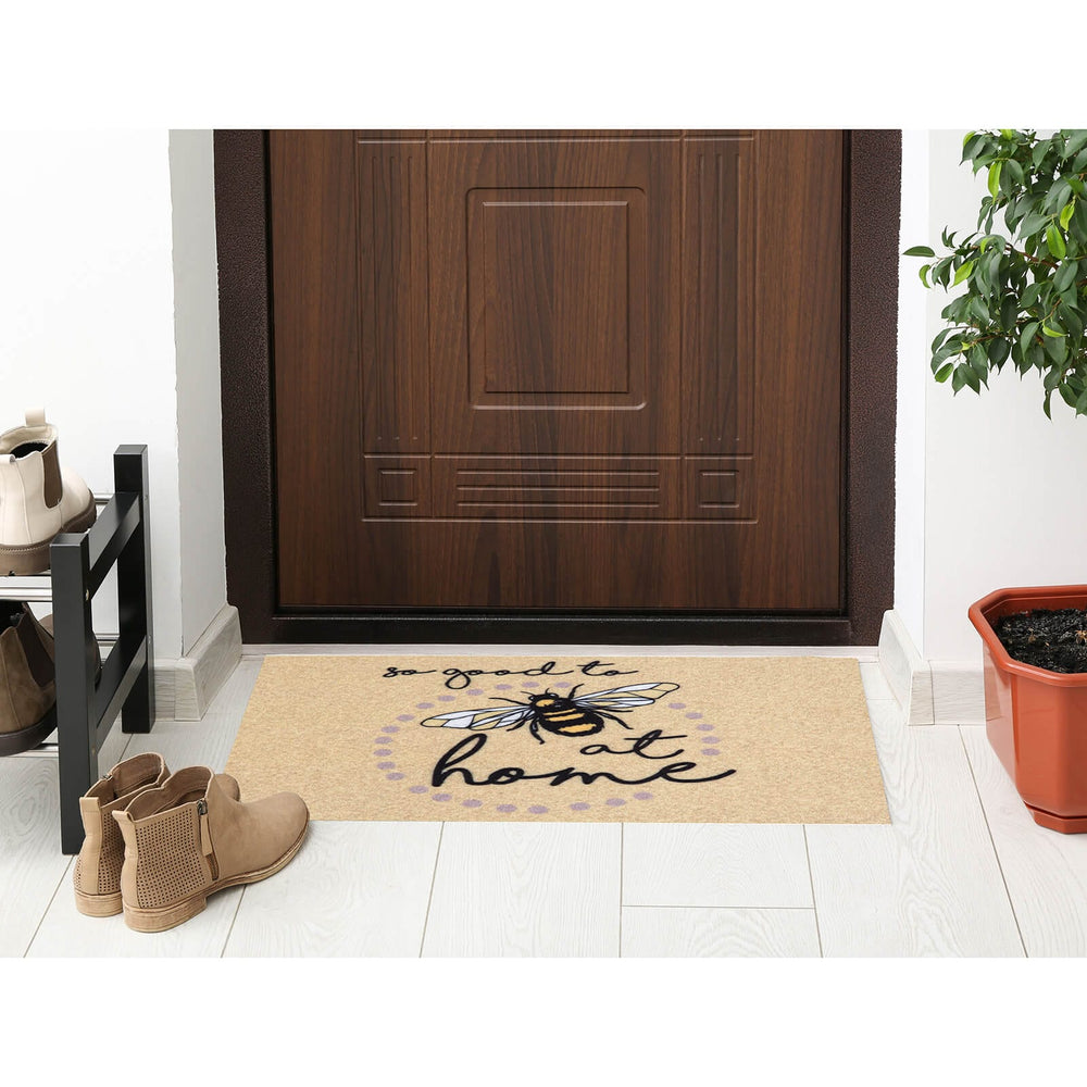 Bumblebee design beige doormat on a floor by a wooden door and planter