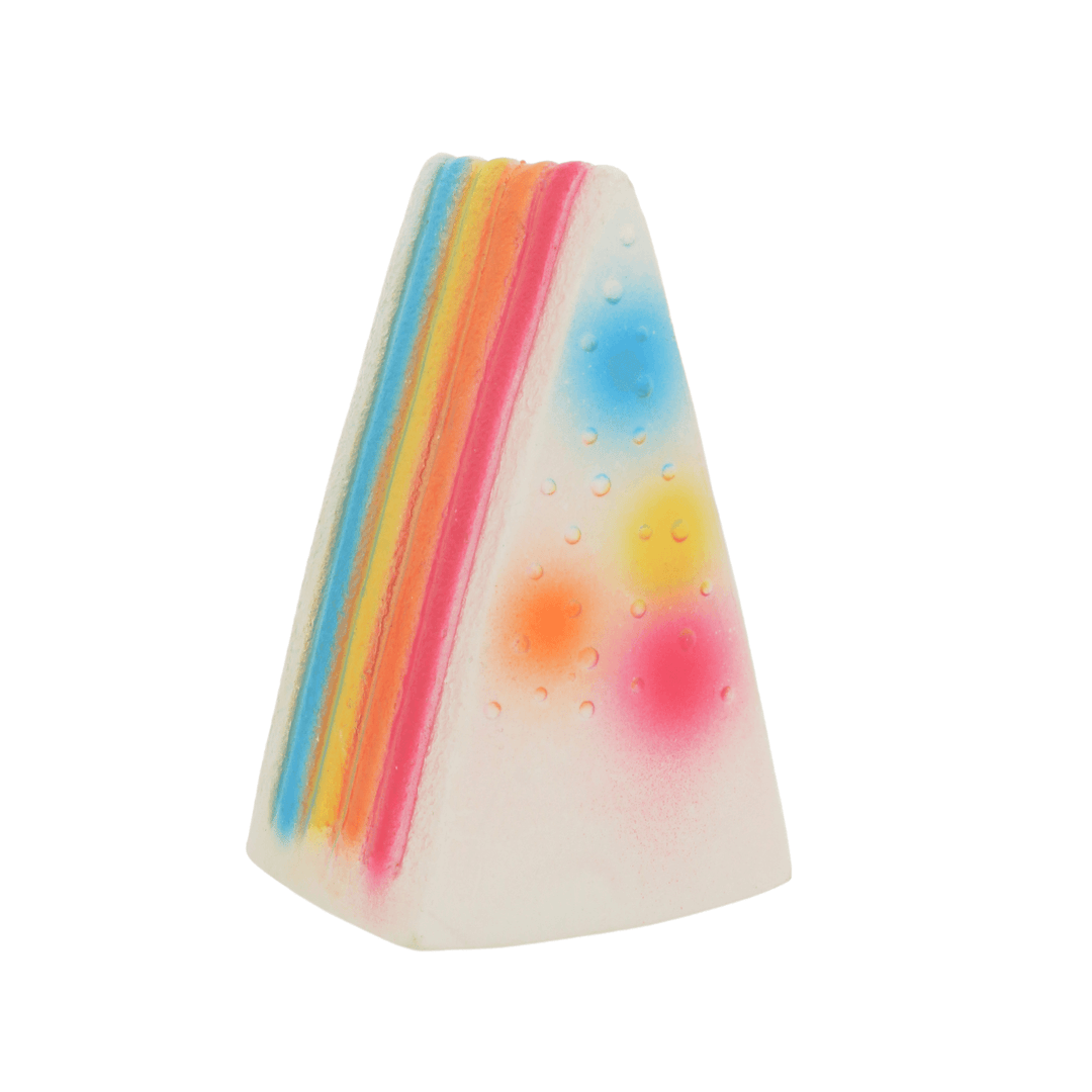 side view of multi coloured dog toy cake slice with pink, yellow, orange and blue layers