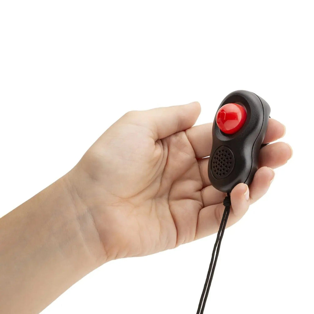 Hand holding a clicker training aid with red clicker button to train your dog