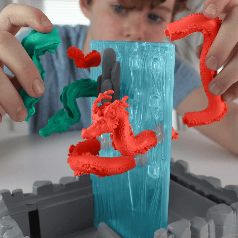 little boy connects two dragon segments to waterfall game grid