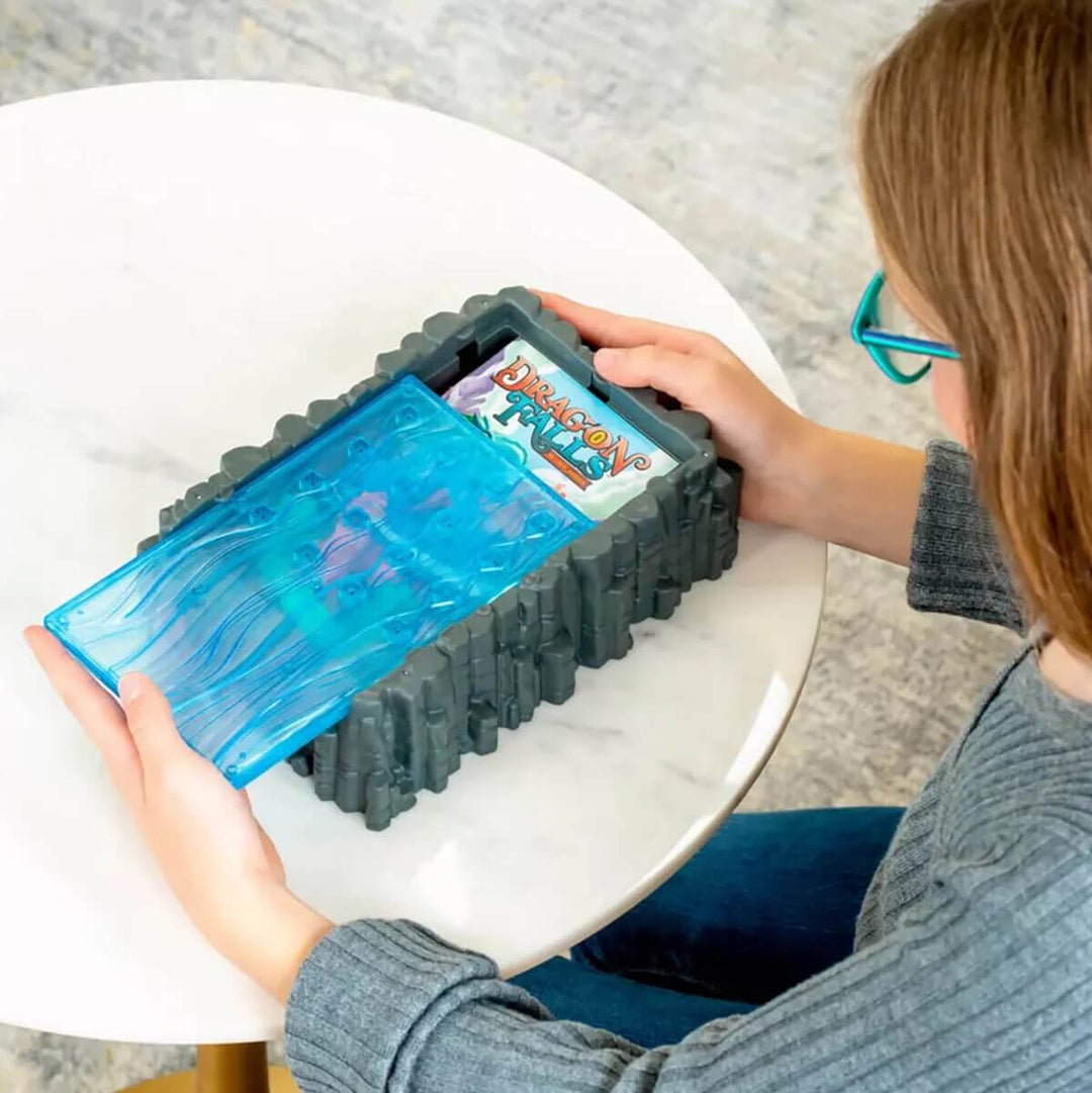 little girl using waterfall segment as cover for came and cards to store inside grid