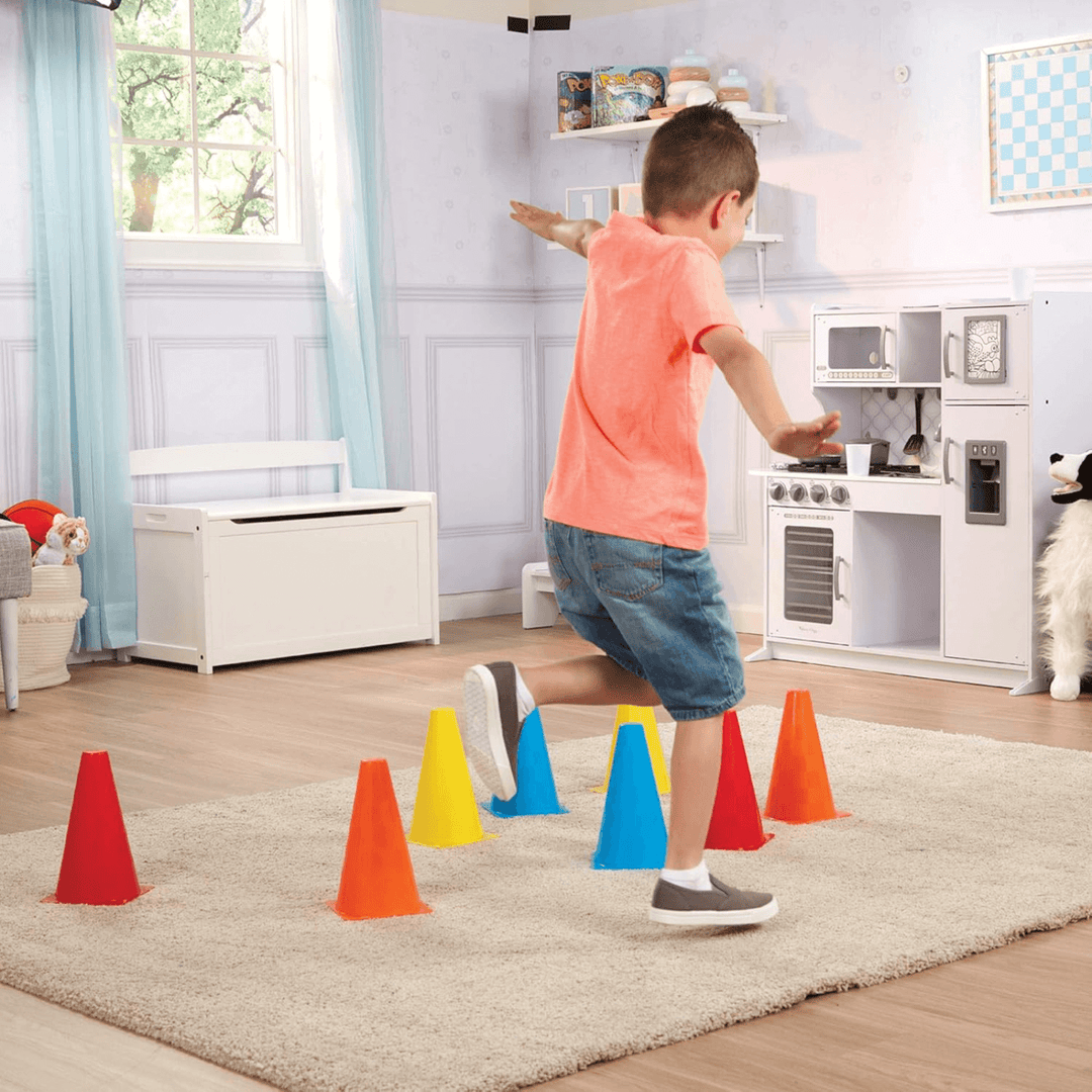 young boy playing in bedroom with activity cones on rug on floor