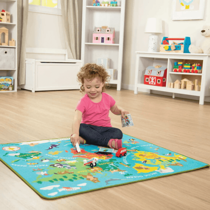 little girl plays on travel play mat in her bedroom with wooden toys in the background