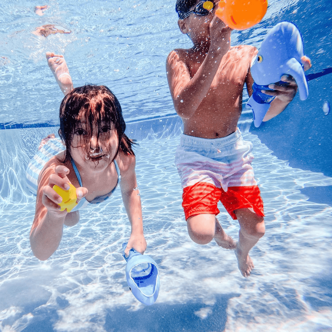 young boy and girl play in swimming pool with shark nets and fish sinkers