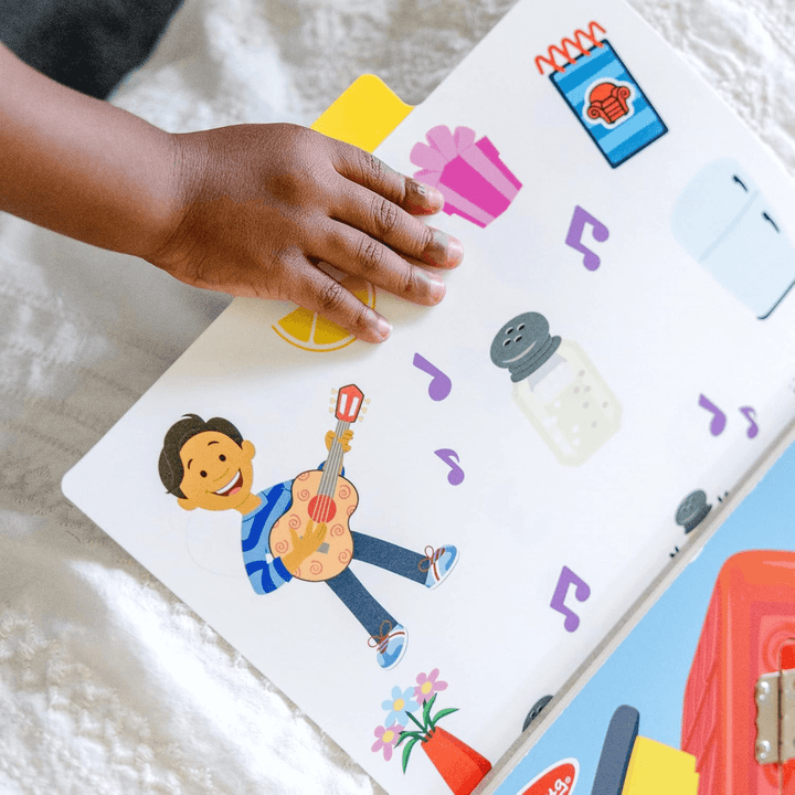 little boys hand holds storytelling card featuring musical notes and a man playing a guitar