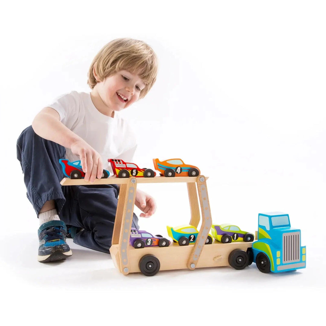 Child playing with a large race car transporter truck