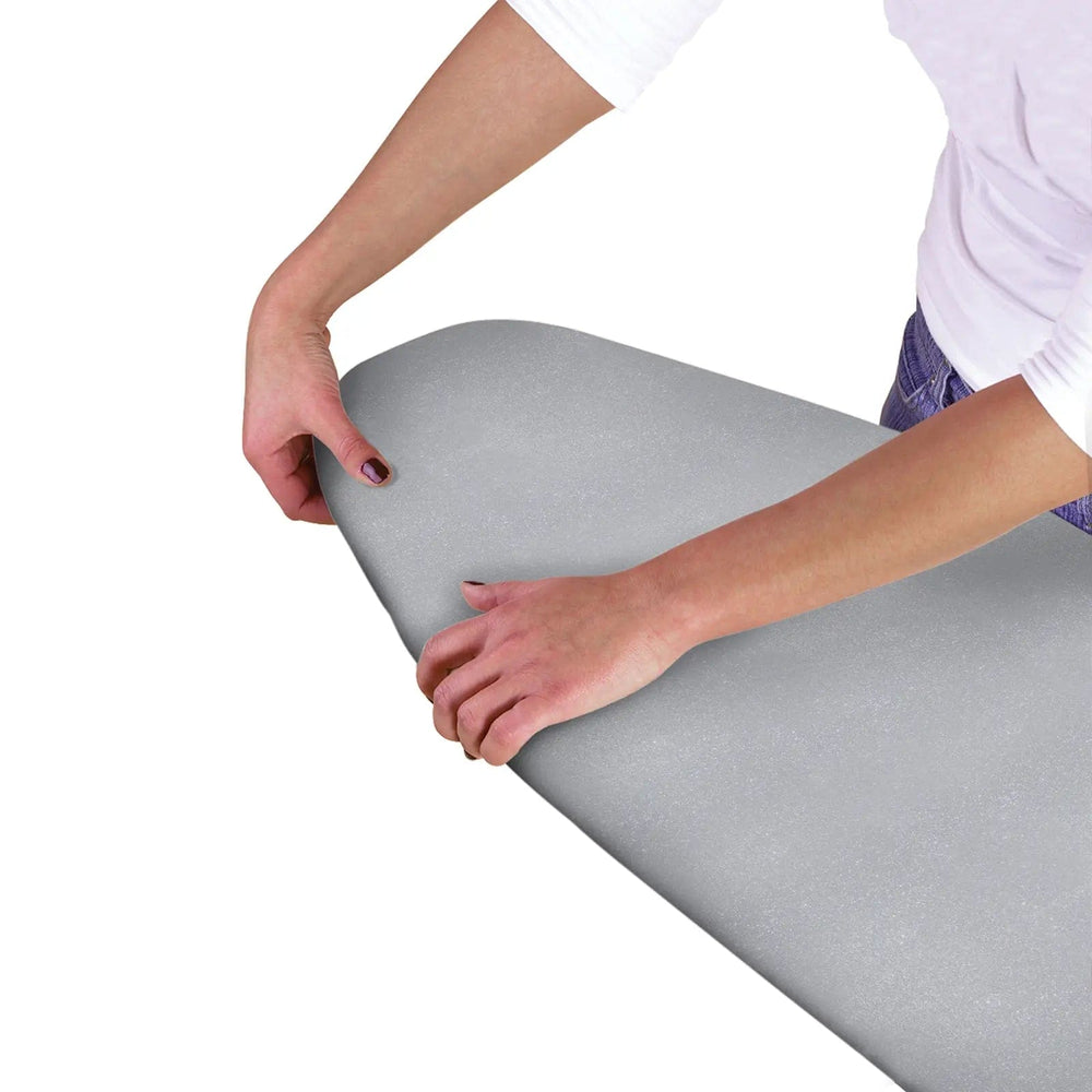 Hands fitting a silver cover on to an ironing board