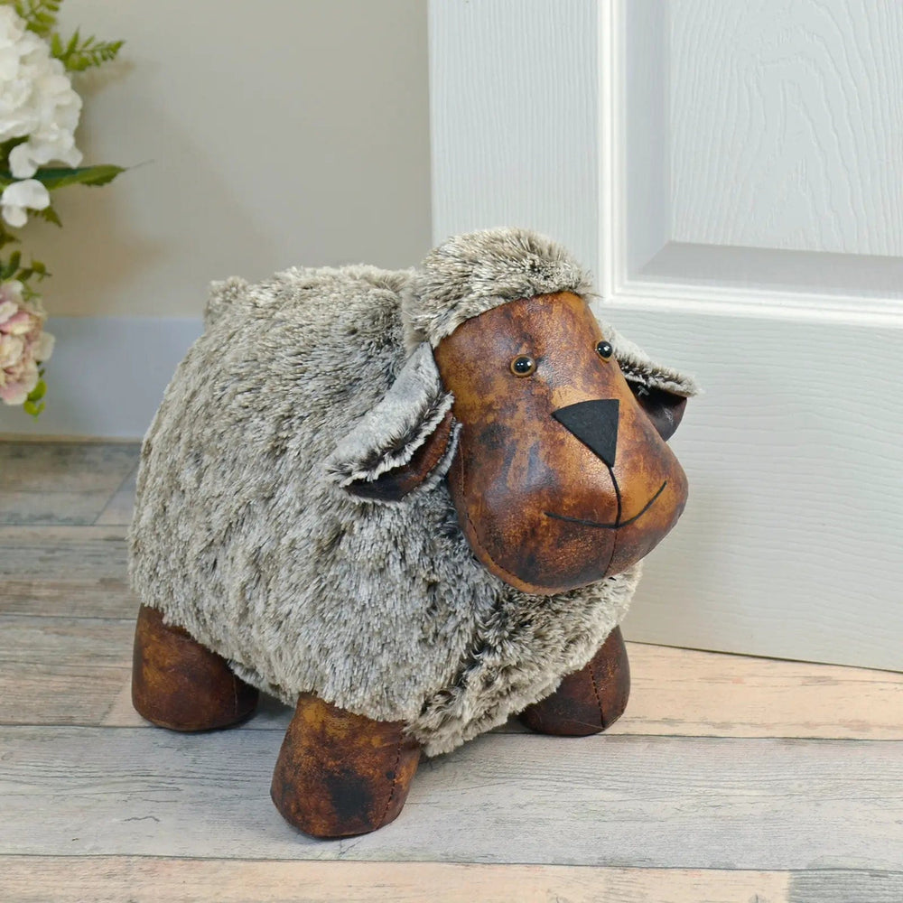 extra large sheep door stop holding open a white door in a room with wood panel floor