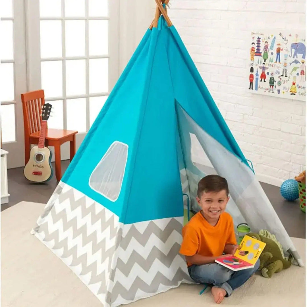 Boy sitting at the flap of a play teepee tent with toys