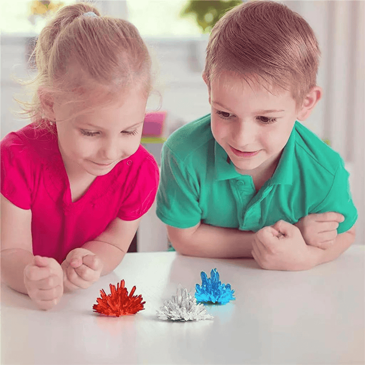 young boy and girl fascinated by the 3 colourful crystals they have created