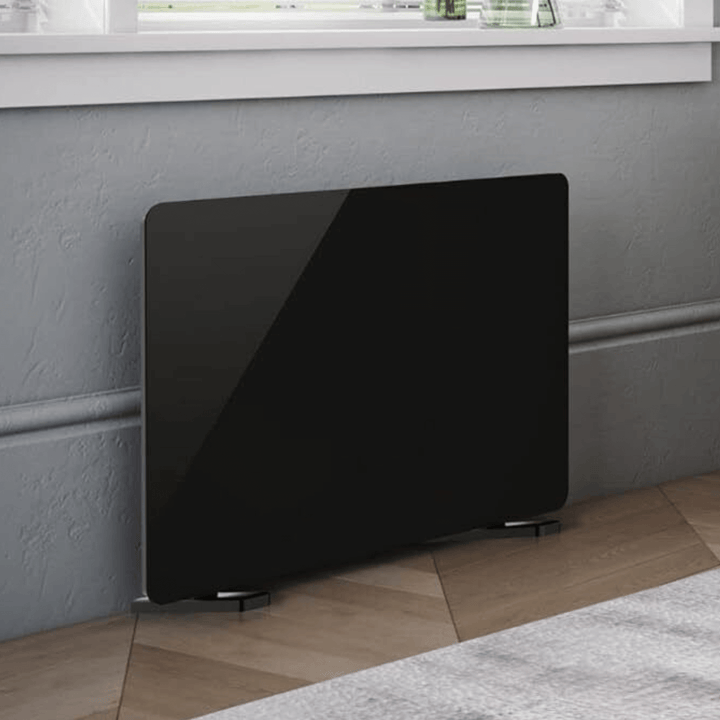 close up of glass panel heater against grey coloured wall on wooden floor