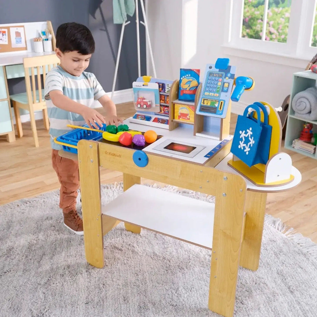 Child playing with supermarket checkout wooden toy with pretend fruit and vegetables