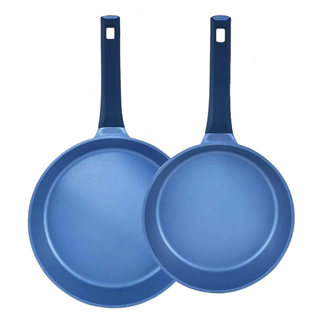 Pair of blue fry pans standing on edge to show inner coating