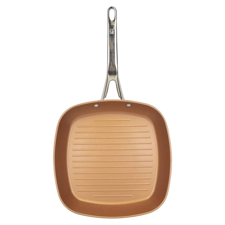 Overhead view of a copper coated, ridged grill pan with stainless steel handle