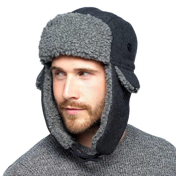 man wearing a light and dark grey fleece trapper hat with long ear flaps fastened under the chin