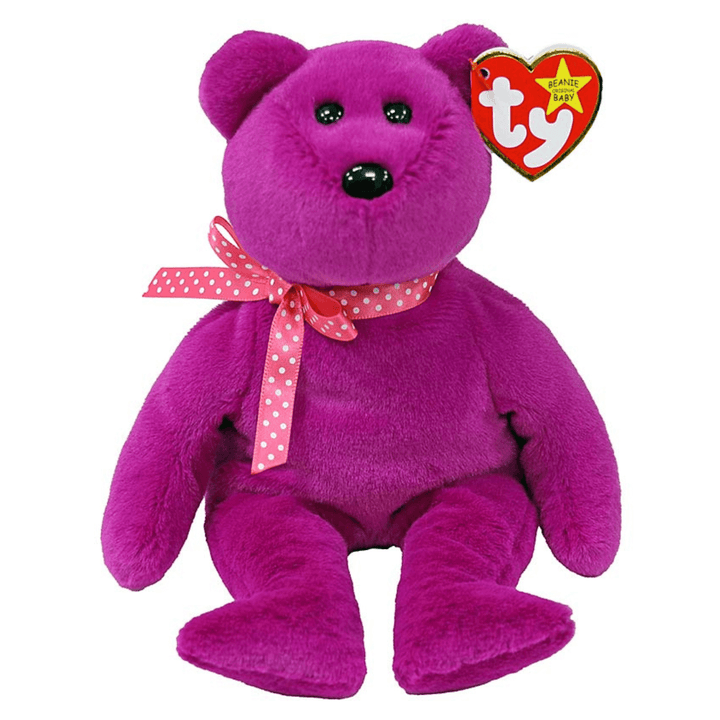 purple coloured ty beanie baby bear wearing pink dotted bow on white background