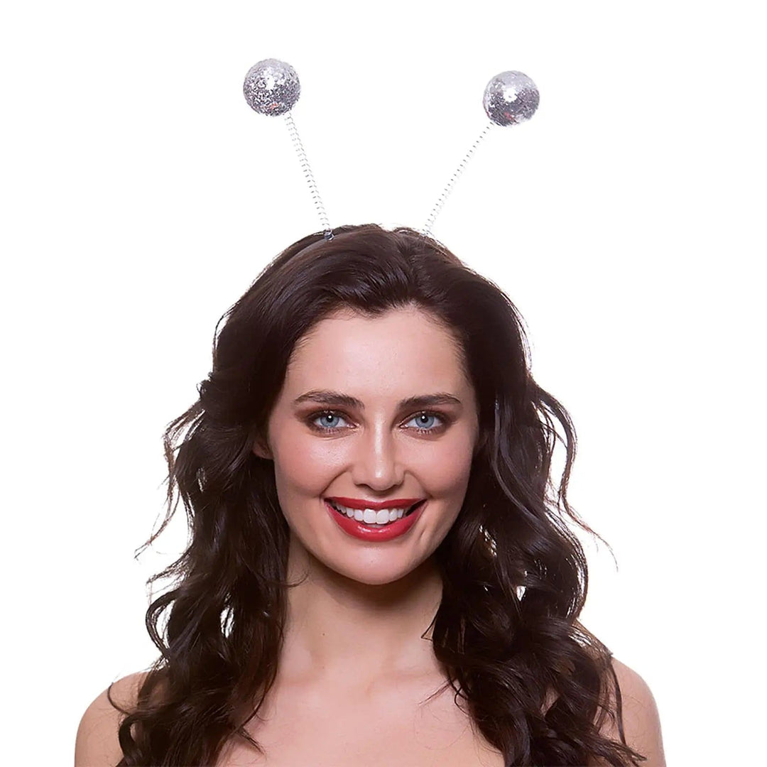 Woman with long dark hair wearing a pair of silver glitter bauble head boppers for party nights