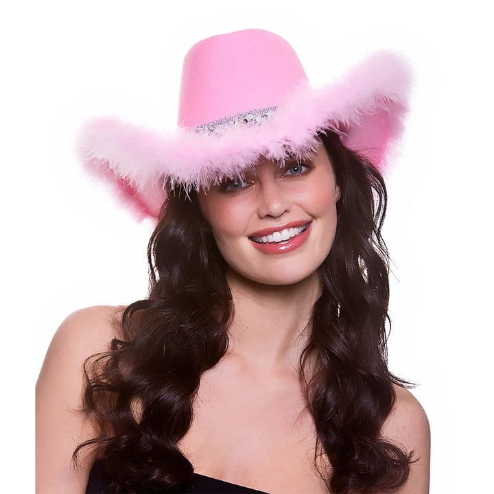 Lady wearing a pink cowgirl hat with silver sequins and pink feathers