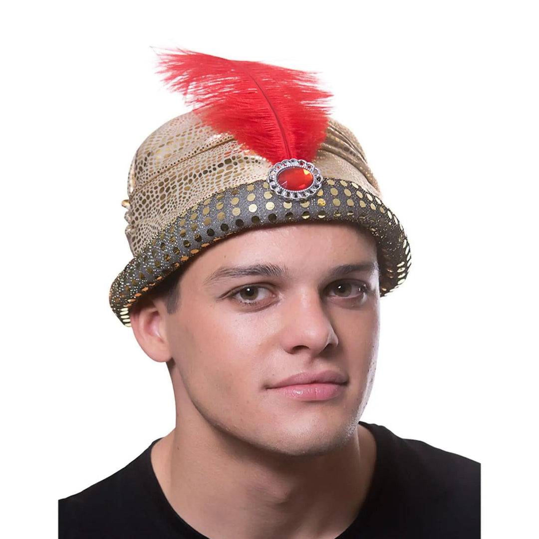 Man wearing an arabian nights sultan hat in gold with red feather and jewel