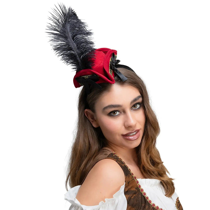 Young lady wearing a luxurious mini pirate hat in red with gold braid and black feather