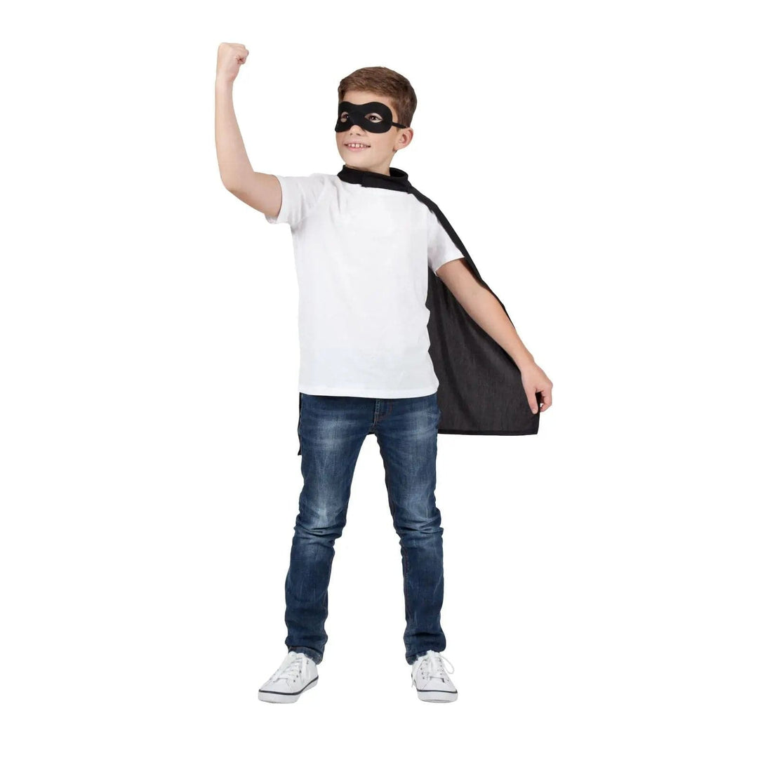 Boy wearing a black eye mask and superhero cape for Halloween fancy dress costumes