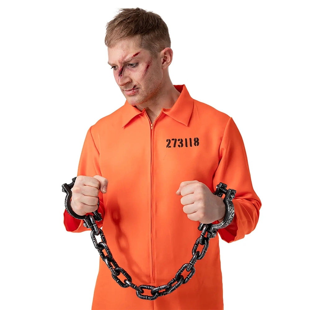 Man in an orange convict bioler suit with hands in chains