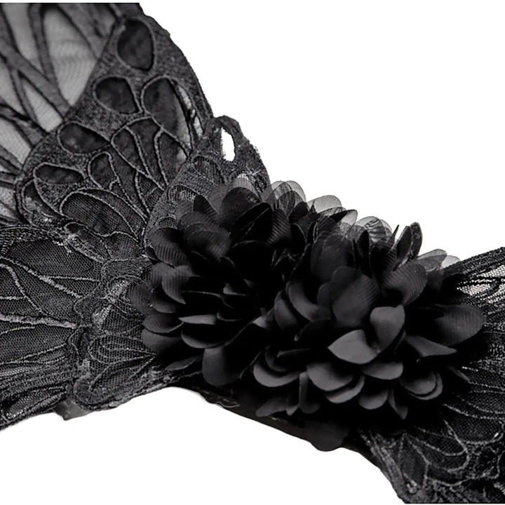 Close up of a black fabric flower on black embroidered lace wings