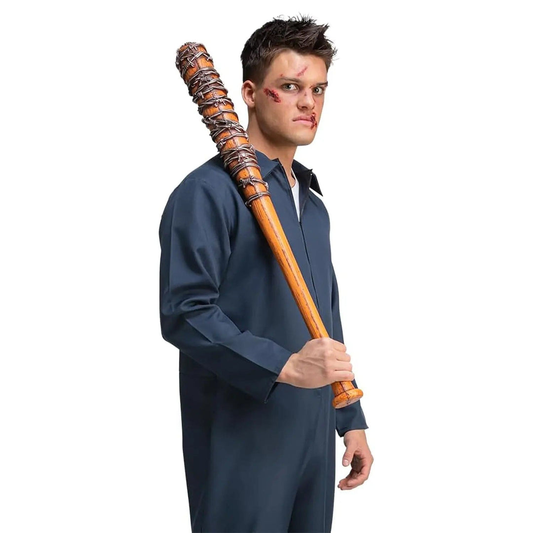 Man wearing a blue boiler suit and holding a baseball bat with pretend barbed wire