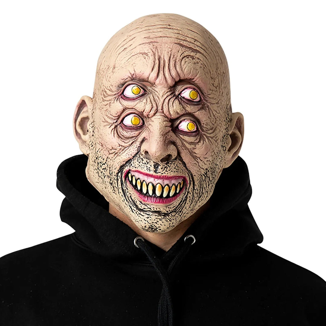 Man wearing a freaky four eyes mask with evil grin and wrinkles skin for Halloween fancy dress costumes