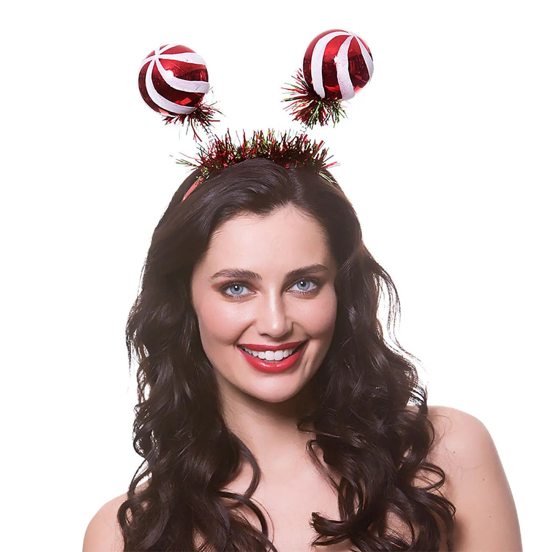 Lady wearing a set of giant bauble head boppers for Christmas parties