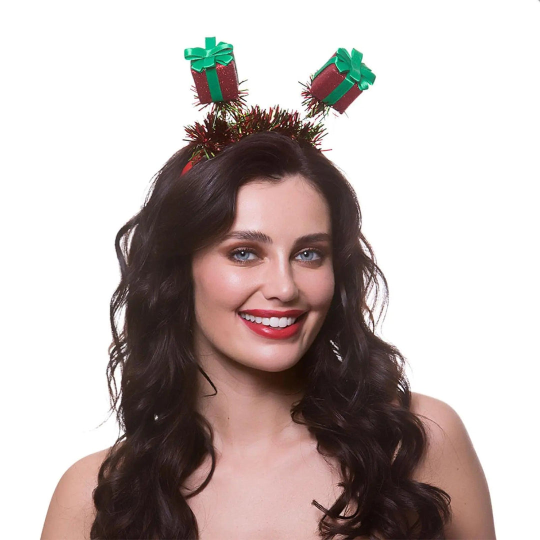 Woman wearing a pair of red and green glittering gift head boppers for Christmas parties