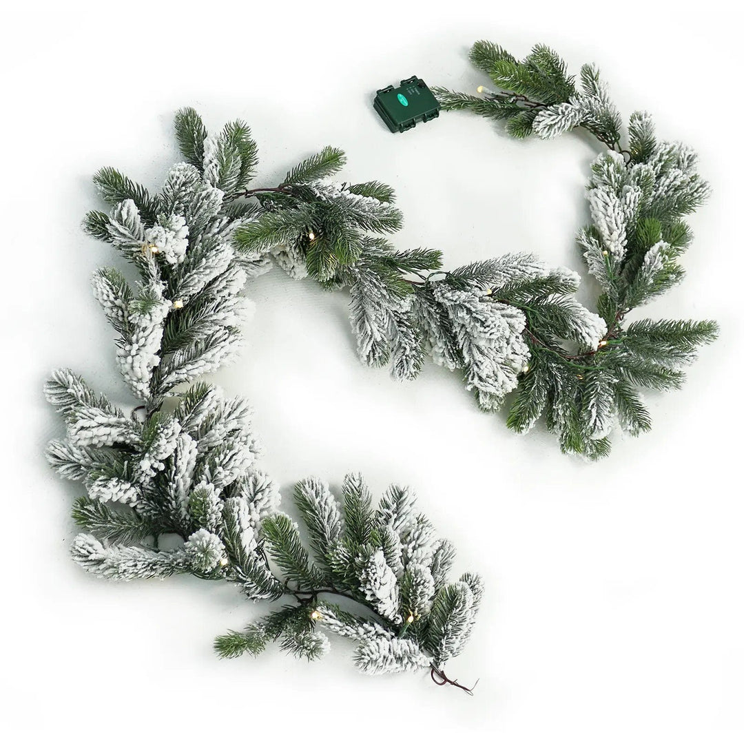 Green Christmas garland with snow flocked branches and warm white lights with battery pack