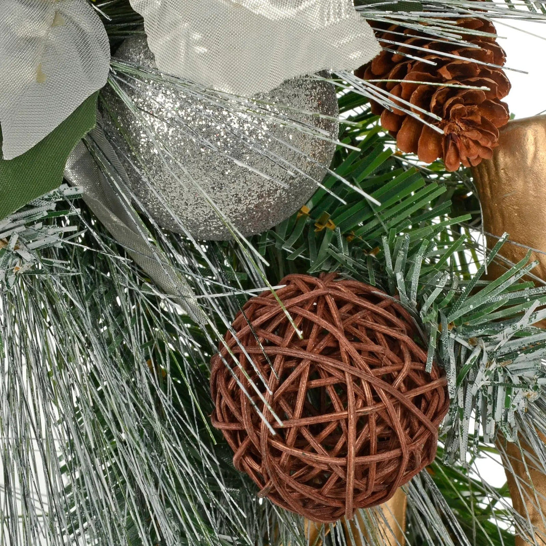 Brown rattan bauble and silver glitter bauble on frosted pine Christmas wreath