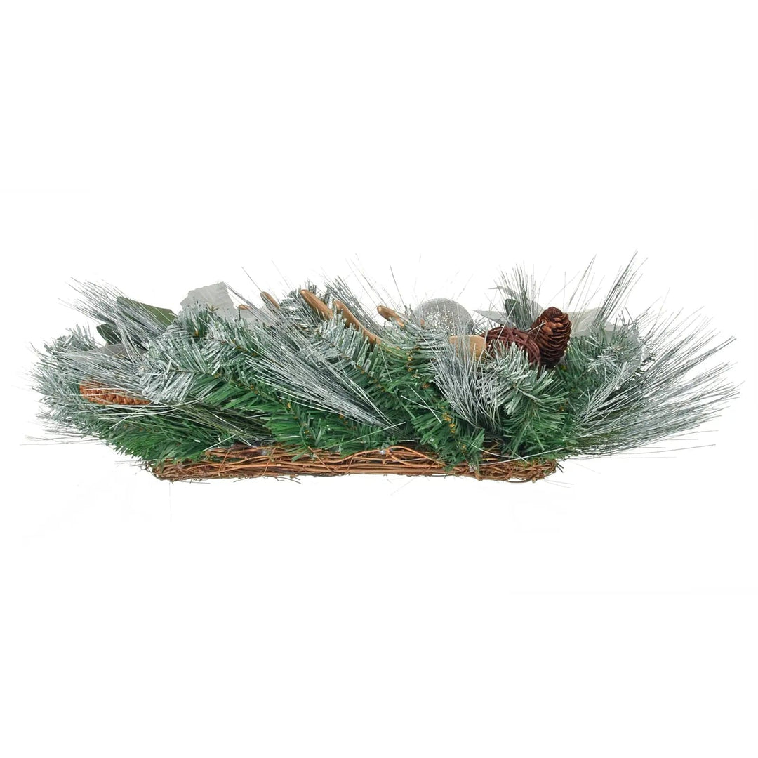 Side view of a Christmas wreath with silver frosted pine branches and woven rattan base