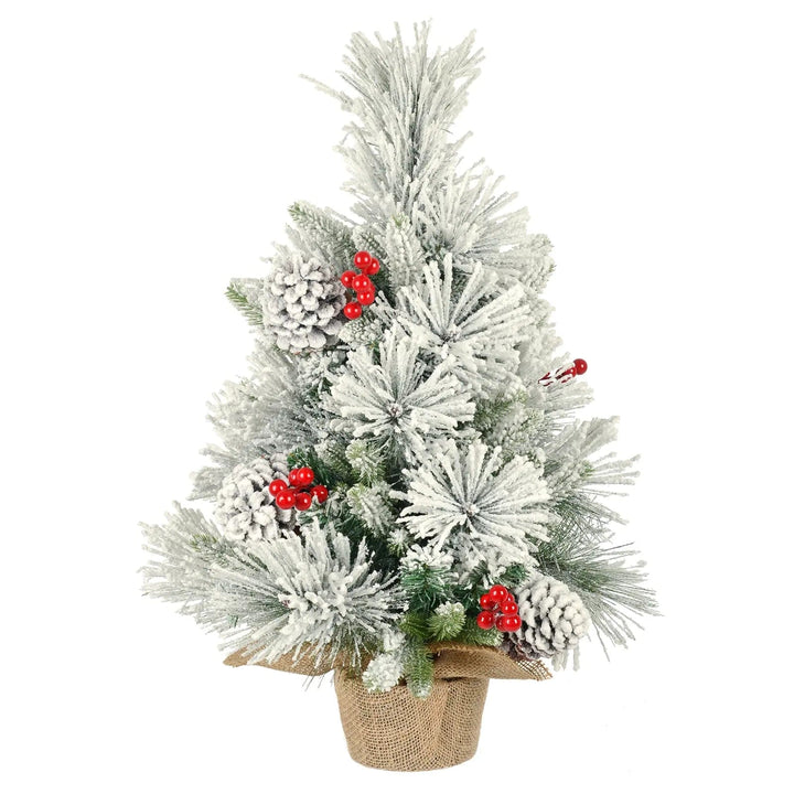 Artificial snow covered Christmas tree with large pine cones and red berries with a jute covered base