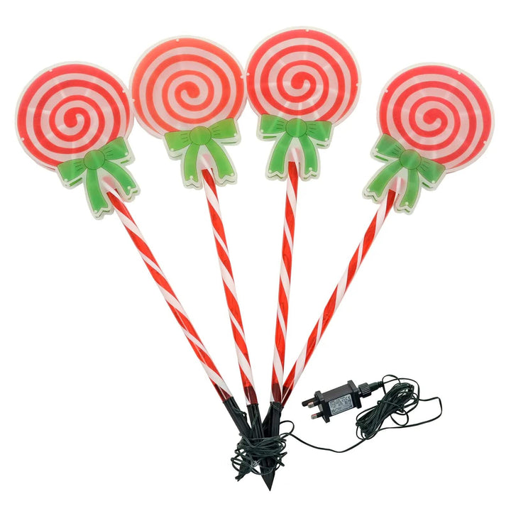 Set of 4 Christmas pathway lights with candy cane lollipop heads, black stakes and a plug in transformer