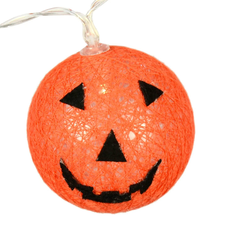 Close up of a Halloween pumpkin light with warm white LED, orange and black fabric cover