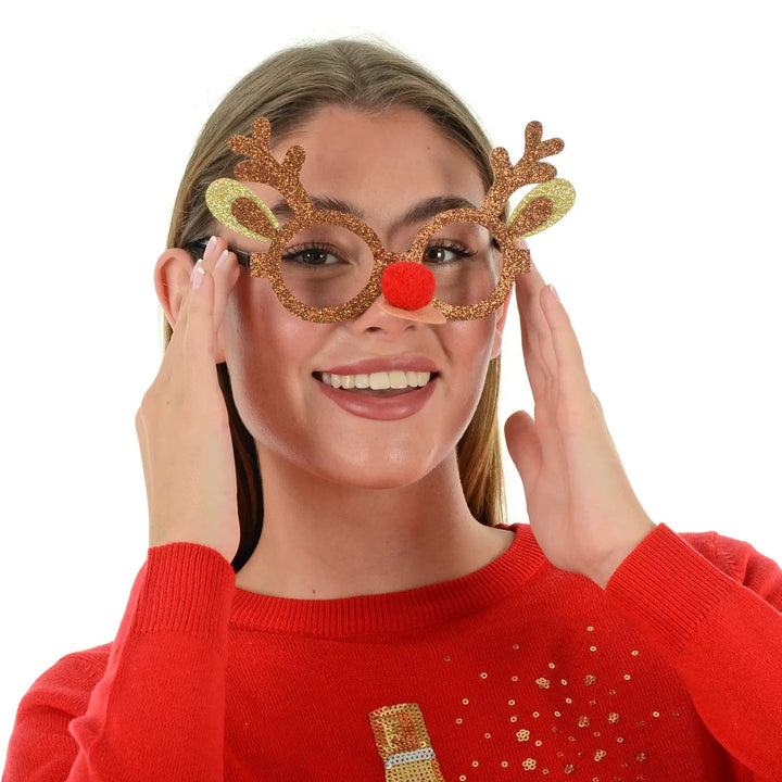 Model wearing Rudolf reindeer novelty glasses with glitter and red pom pom nose for Christmas parties