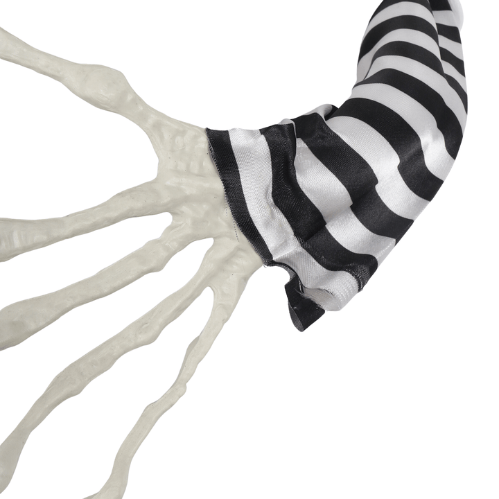 close up shot of spooky skeleton hand with striped satin top sleeve